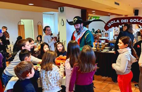 Animatore vestito da pirata intrattiene bambini in un ristorante.